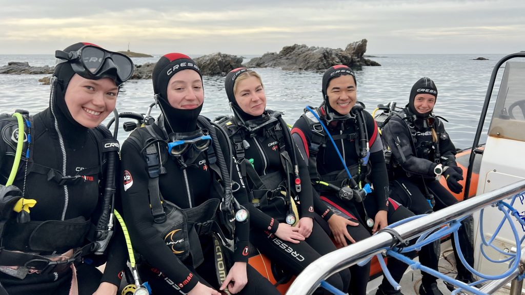 Students in diving gear on boat